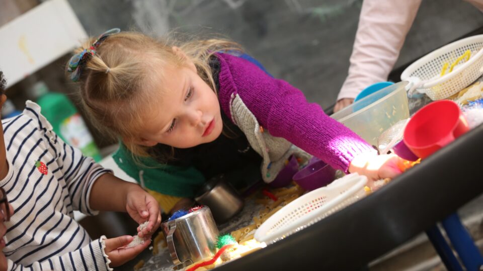 Two children at a preschool engaging in sensory play, highlighting the creative environment in areas with top West Sussex and Hampshire Ofsted ratings.